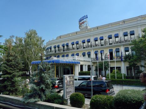 The hotel has a beautiful facade and a blue canopy from the rain and sun
