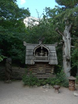 carved wooden tower with statues of animals from the fairy tale "Teremok" among the dense green trees. a fabulous resting place for the whole family