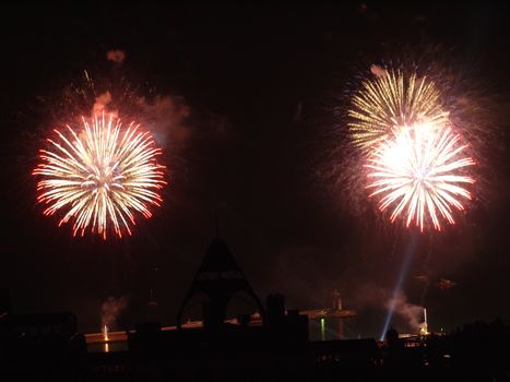 colorful explosions of a salute in the night sky against a background of city buildings