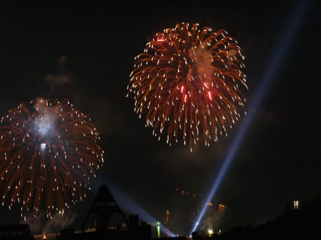 Rain from the bright festive lights of the salute in the night sky
