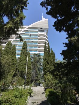Steps leading to the high modern sanatorium building against the backdrop of lush green cypresses
