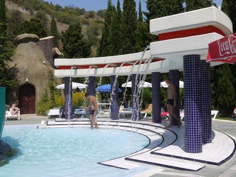 Clean water which can be rinsed after the pool flowing from the stainless pipes in the park on a hot summer day.