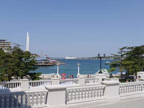 embankment with a white fence against a calm blue sea