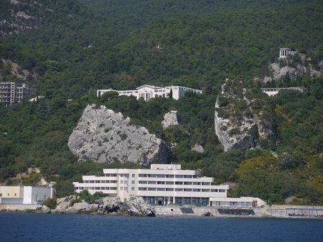 large rocky boulders at the foot of the mountain with its hotels located by the sea
