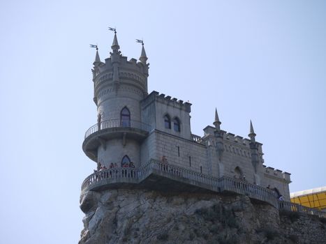 Beautiful stylized building under the antiquity, with towers and flags on the rock. The perfect place for a photo to remember
