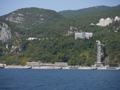 Beautiful landscape of a sea surface resting on a sandy beach. With a green mountain slope behind it covered with green vegetation.