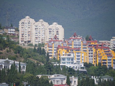 high modern houses and private villas and hotels amidst green trees on the slope of a forested mountain. place of rest, travel and tourism