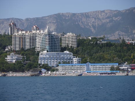 Modern seashore with skyscrapers and a beach and mountains in the background. Every tourist wants to relax there and sunbathe
