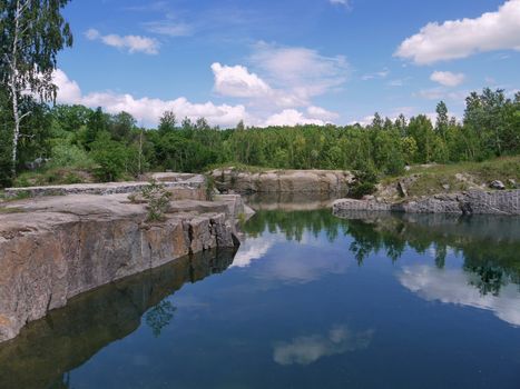 a small quiet pond with clear water lying between the stone banks