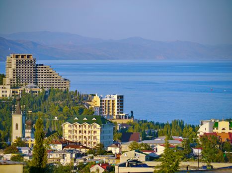 A panorama of the city with hotels on the beach near the bay and the distant mountains