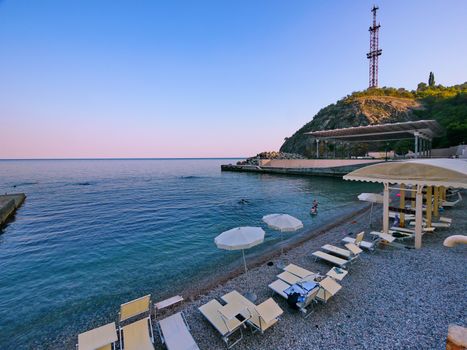 Comfortable beach on the sea coast with sun beds, umbrellas and a special cover for tourists