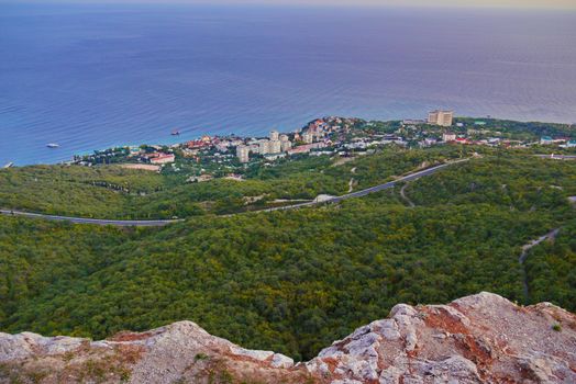 A picturesque view of a large village with sanatoriums and holiday homes against the backdrop of the endless blue sea