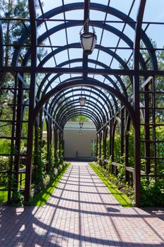 beautiful alley lined with tiles going through an arch of metal structures