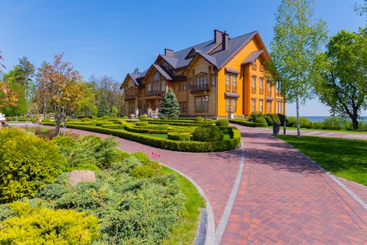 red stone path to a wooden house with a beautiful garden landscape