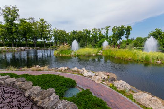 a cascade of fountains on a lake with rocky shores and an island in the middle of the park