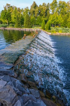 beautiful small waterfall on the river with ducks