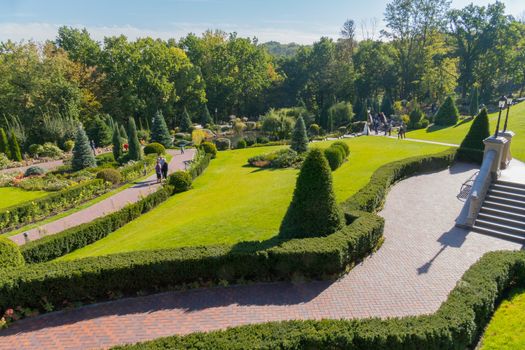 A panorama of the park with beautiful landscape design made of shrub shrubs, flowers and green lawns. Mezhygirya Ukraine