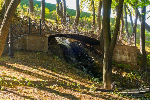 A small decorative waterfall with several forged bridges along the course of its current