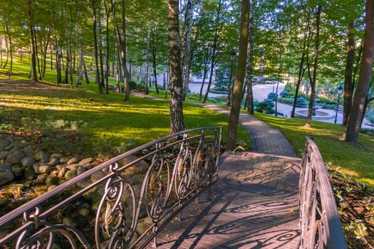 A small bridge across the lake leading to a modern building in the distance