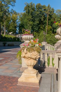 Decorative stone flowerbeds, decorated with sculptures of stucco on the background of the green park zone