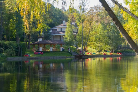 Recreation area for tourists with wooden pavilions and soft puffs in the background of a decorative lake