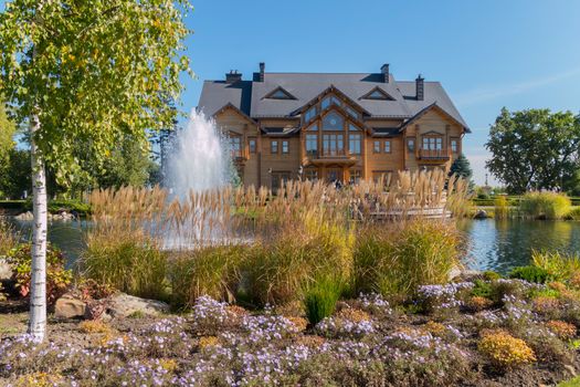 high fountain on the lake in front of a wooden house with balconies