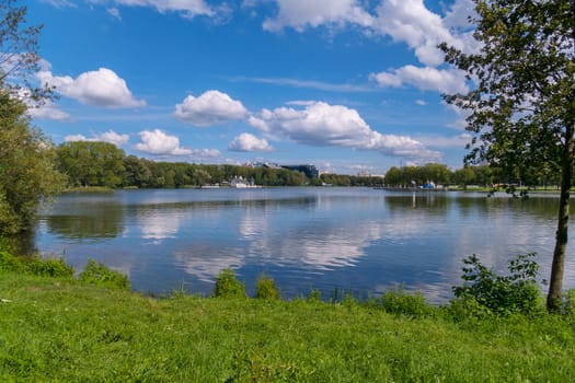 fluffy white clouds float through the blue sky over the calm flat water