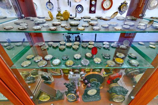 A variety of pocket watch in the collection behind the glass. With gold-plated lids of steel color with engraving.