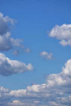 A huge, endless blue sky with large, lush white clouds