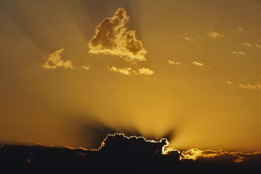 An unforgettable sight. Struggle of black clouds and golden sun rays. The play of light and shadow