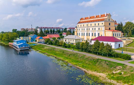 Several buildings of different sizes near the blue lake and the green coastal zone
