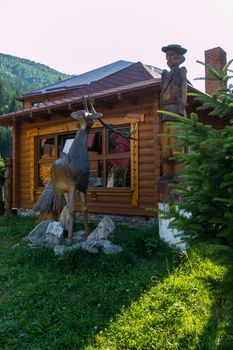 wooden reindeer on stones near the Hutsul house in the mountains