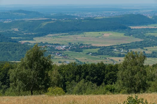 A panorama of green hills and valleys with wide openings on them
