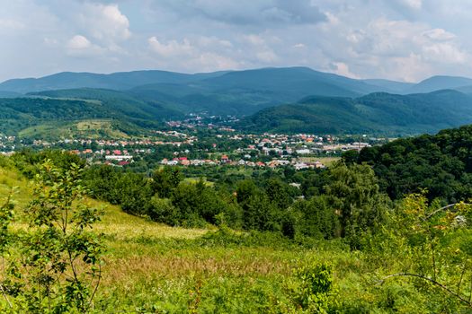 A cozy rural village with small houses in the background of the boundless green mountains