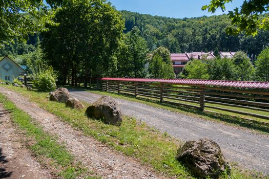 rural street with an original fence and large boulders