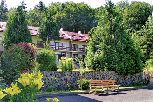 Beautiful villa with a red roof in the thickets of green trees