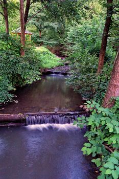A cozy wooden gazebo in the background of a decorative river channel