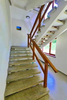stone staircase with wooden railings and a picture between the floors