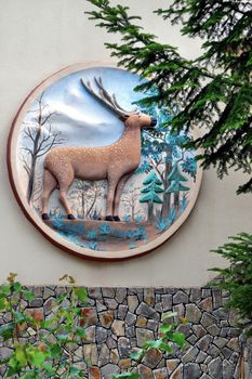 Clay, a large picture on the wall with a brown deer and trees