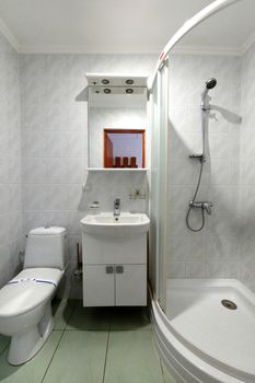 A small adjacent bathroom with toilet, washbasin and a comfortable shower cubicle