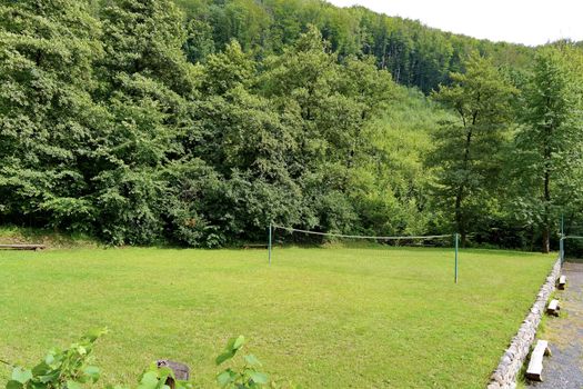 stretched between two pillows net for volleyball on a green lawn in the middle of the forest