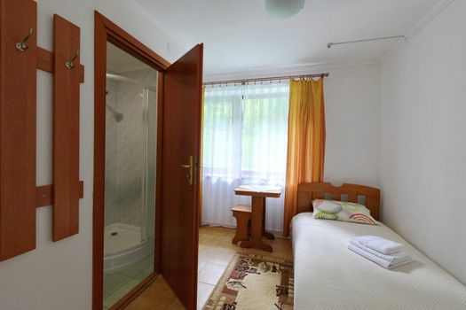 A small hotel room with a combined bathroom. And one bed
