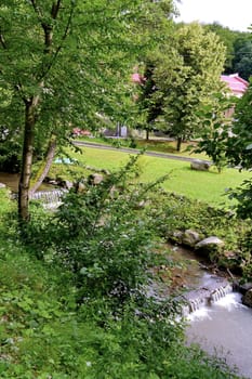 The thresholds of a small river against the backdrop of a beautiful park area at the hotel complex