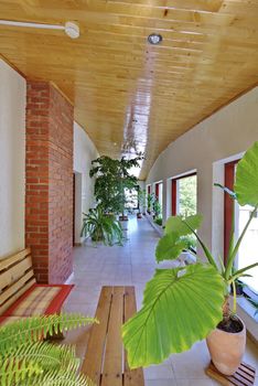 Hall with a wooden ceiling and tiled floor and a huge number of decorative flowers