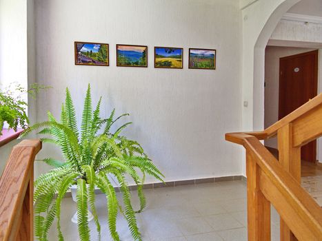 wooden railing near the stairs in the hotel corridor hung with pictures