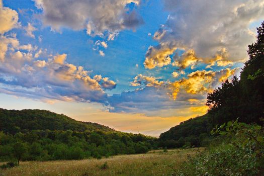 Mountain valley illuminated by the rays of the evening sun before sunset