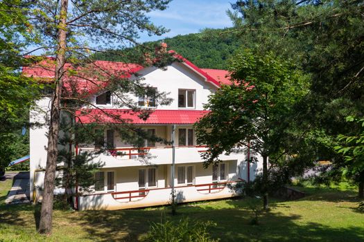 Cozy three-storey holiday house with wide balconies, white walls and a red roof