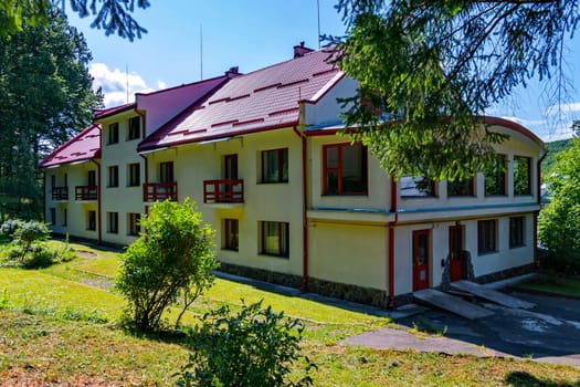 Two-story hotel complex with balconies and a red roof near the park zone