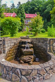 A miniature waterfall in the form of a stream of water running downwards over the stones laid out by hand.