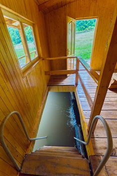 Entrance to a wooden bath with a staircase leading to a small pool with cold water